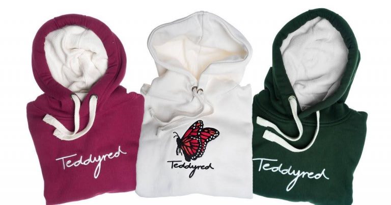 Three folded hoodies are displayed: one purple, one white with a red butterfly graphic, and one green. All feature "Teddyled" text on the front. Each hoodie has white drawstrings.